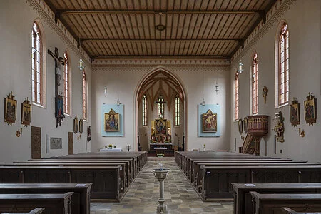 Innenansicht der Kirche St. Nikolaus, mit Kanzel auf der rechten Seite und dem ihr gegenüberliegendem Kreuz, sowie direktem Blick auf den Altar, den Hochaltar und die beiden Seitenaltäre