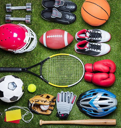 High Angle View Of Various Sport Equipments On Green Grass