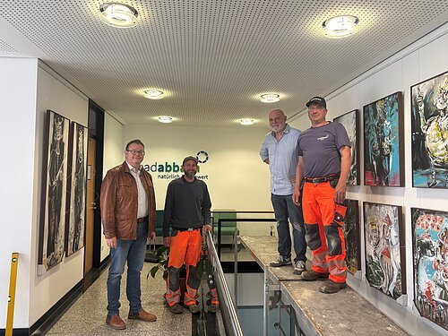Bürgermeister, Künstler und das Team des Bauhofs arbeiten Hand in Hand beim Aufbau der neuen Dauerausstellung – ein Blick hinter die Kulissen voller Engagement und Teamgeist.