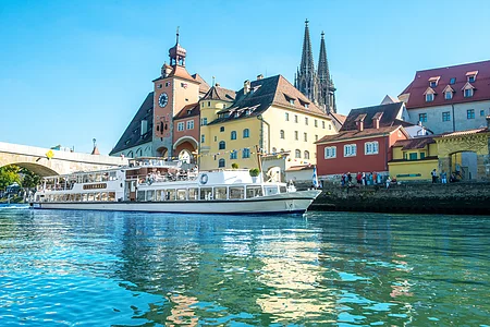 Das MS Bruckmadl durchfährt die Steinerne Brücke in Regensburg