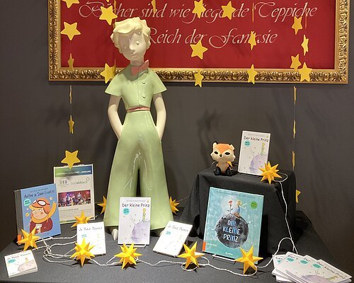 Der Kleine Prinz in der Marktbücherei Gastgeschenk unserer Partnerstadt Charbonnieres-les-Bains - Figur und Bücher