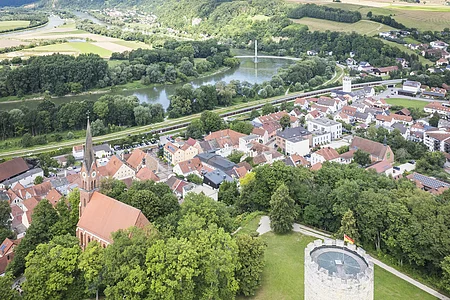 Luftbild Burgberg Luftaufnahme einer Stadt mit Kirche, Turm und Fluss in einer grünen Landschaft.