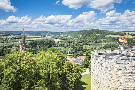 Blick vom Burgberg Luftbild vom Heinrichsturm mit dem grünen Donautal im Hintergrund. Der Himmel ist blau-weiß.