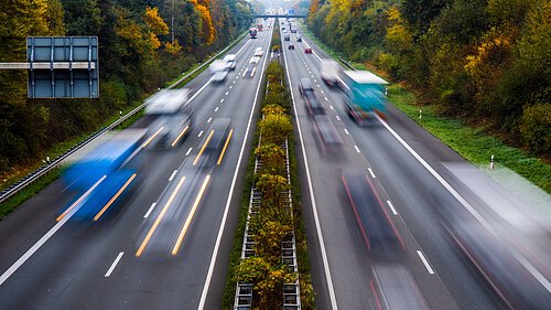 Autobahn mit Autos und LKW im Herbst