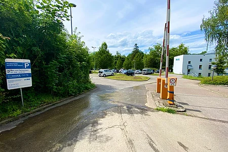 Einfahrt zu einem Parkplatz mit Schranken und einem Schild für Privatparkplatz Klinikum Bad Abbach.