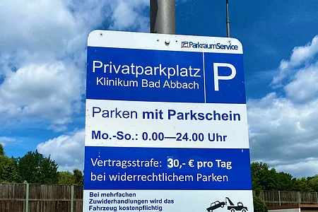 Schild für Privatparkplatz Klinikum Bad Abbach, Parken mit Parkschein, 30 Euro Strafe bei Falschparken, Abschlepphinweis.