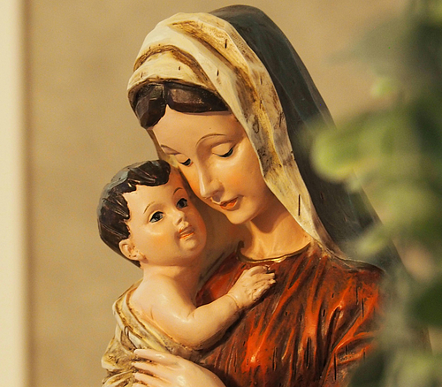 Statue einer Frau mit Kopftuch, die ein Baby im Arm hält und liebevoll anschaut.