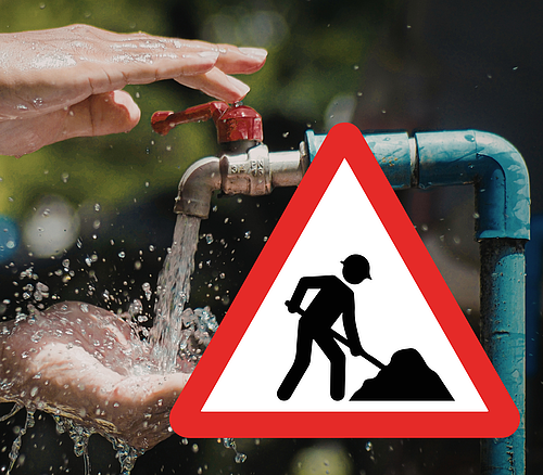 Wasserhahn mit laufendem Wasser und Händen, davor ein Baustellenschild mit rotem Rand und schwarzer Figur.
