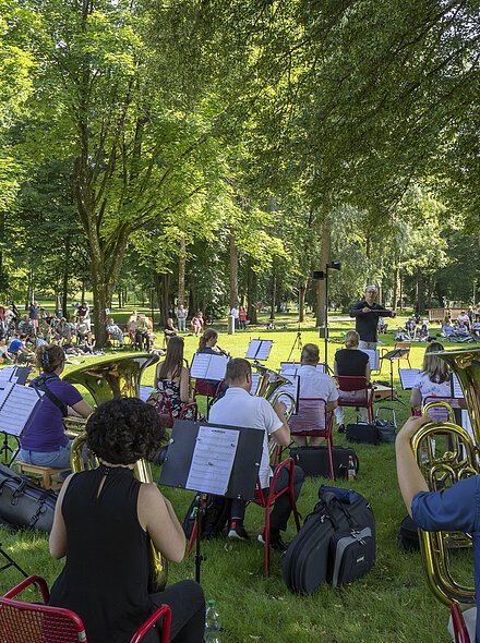 Markt Bad Abbach Kurpark Öffentliche Probe mit Gästen Symphonisches Blasorchester Regensburg Orchester spielt im Park vor Publikum auf Wiesenfläche unter Bäumen bei Tageslicht
