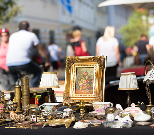 Flohmarkt in Bad Abbach Antiquitäten und Vintage-Objekte auf einem Flohmarkt mit unscharfen Personen im Hintergrund