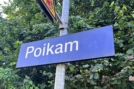 Schild am Bahnhalt in Poikam